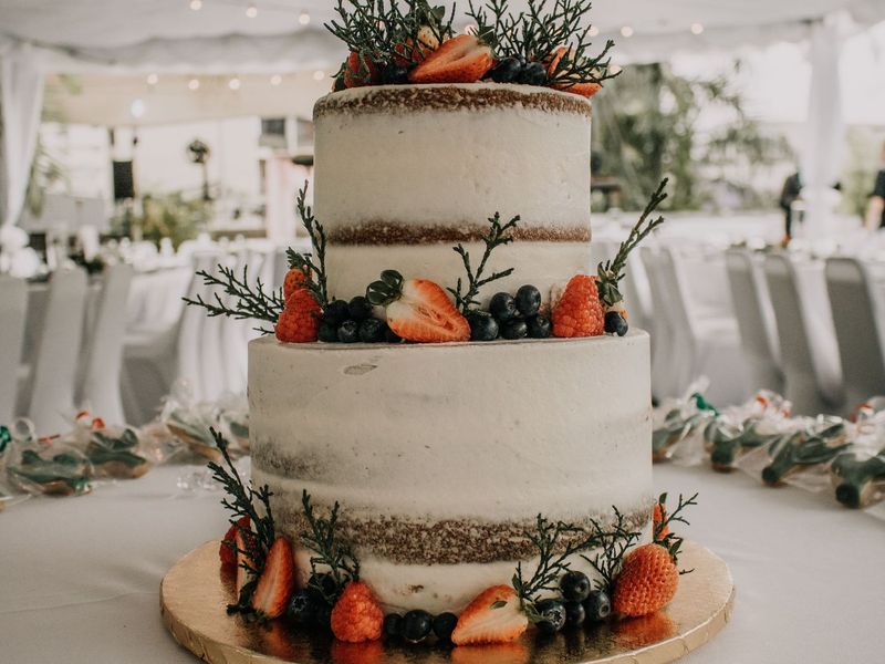 Zweistöckiger Seminaked Cake mit frischen Beeren unter Lichterketten